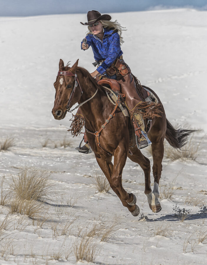 Tracy Webb-Kaden competing in mounted shooting at White Sands National Monument riding in a TW Saddlery saddle