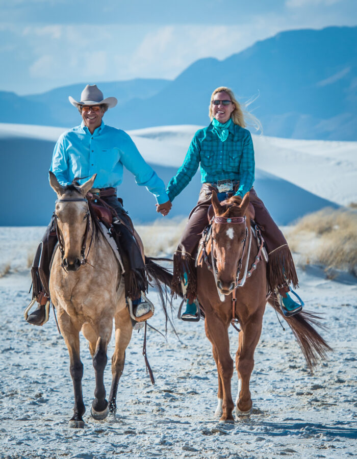 David and Tracy Kaden riding horses at White Sands National Monument in TW Saddlery saddles
