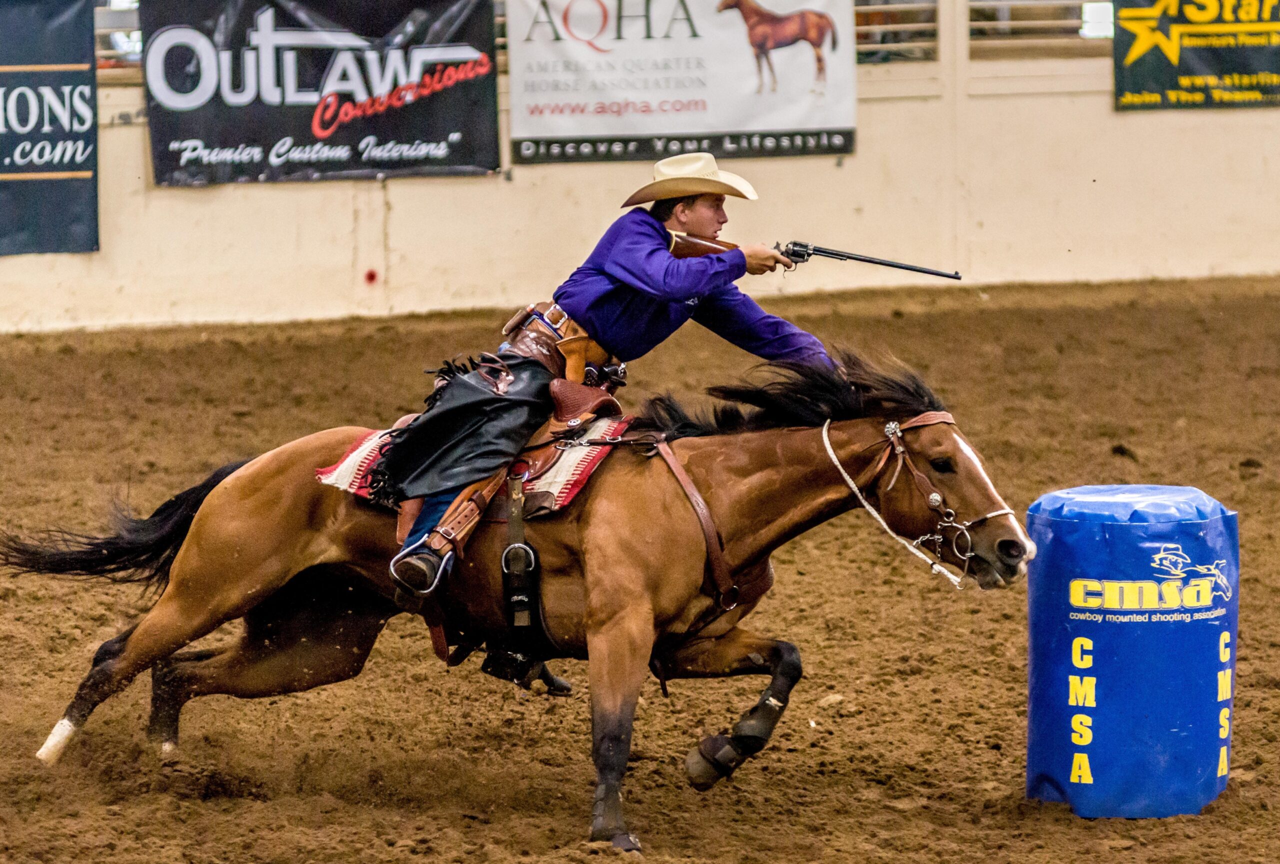 Cowboy mounted shooting horse and rider competing in a TW Saddlery saddle