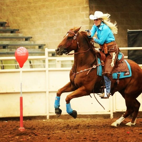 Cowboy mounted shooting horse and rider competing in a TW Saddlery saddle
