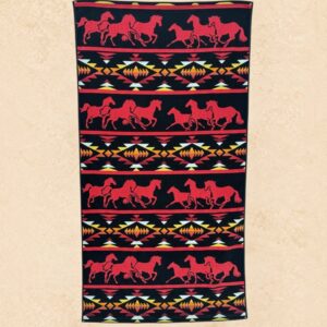 Red Rock Stampede western beach towel with red running horses and southwestern geometric pattern on a black background