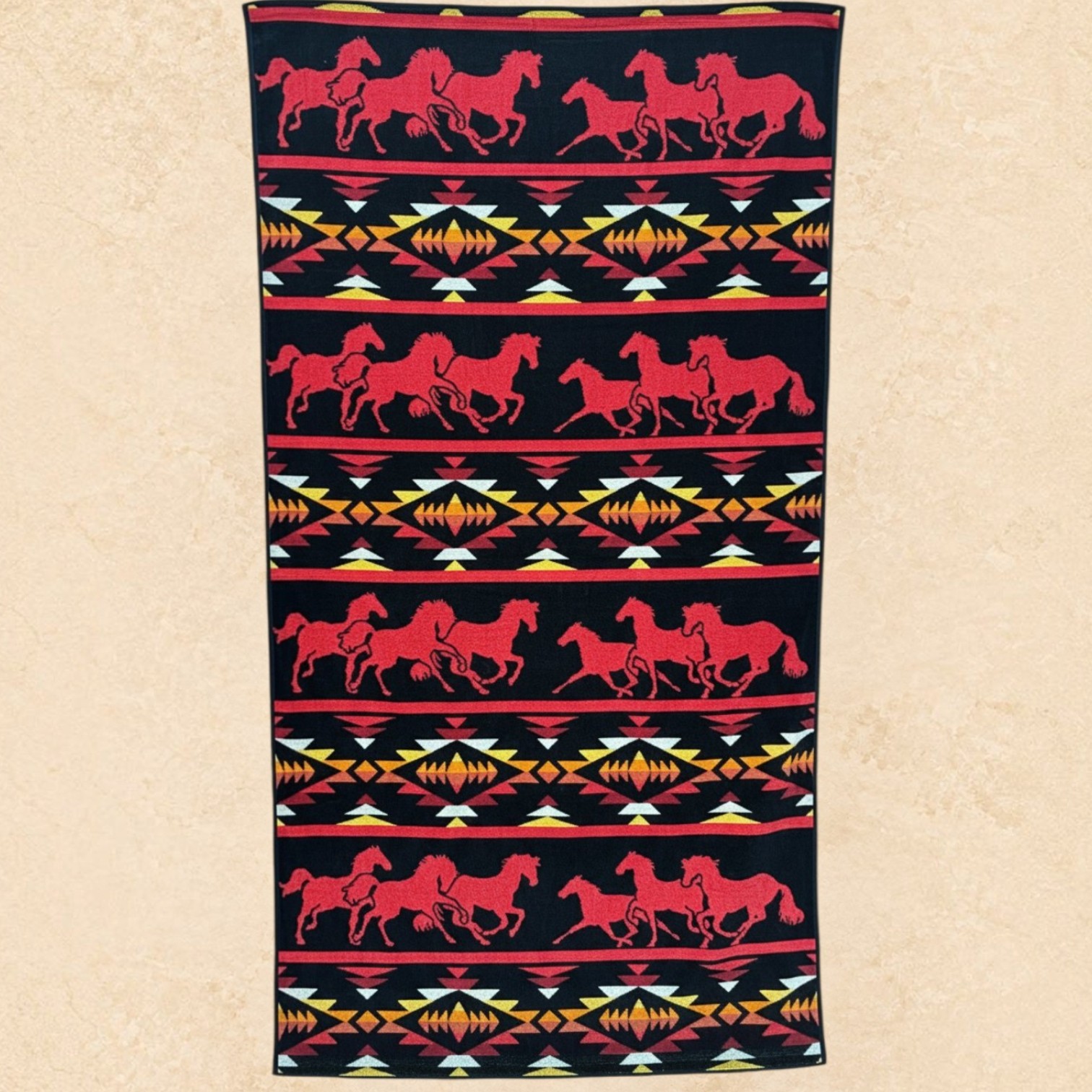 Red Rock Stampede western beach towel with red running horses and southwestern geometric pattern on a black background