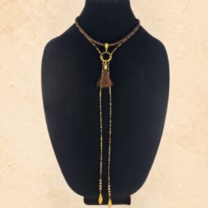 Brown, copper and gold Western lariat-style necklace with braided detailing, horsehair tassel and gold feather accents.