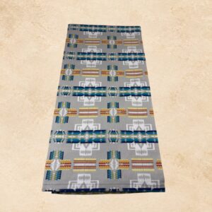 Silver Mesa tea towel with a gray background and turquoise, blue, white, yellow, and rust Southwestern geometric patterns.