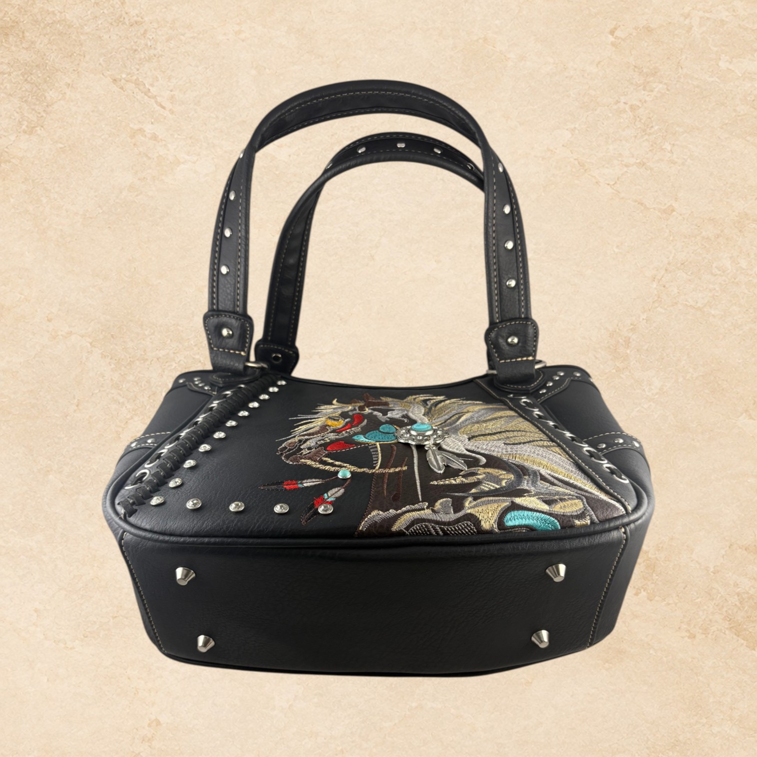 Side view of black leather horse purse with studded trim