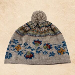 Soft taupe alpaca knit beanie with blue floral pattern, colorful embroidered flowers and matching pom-pom