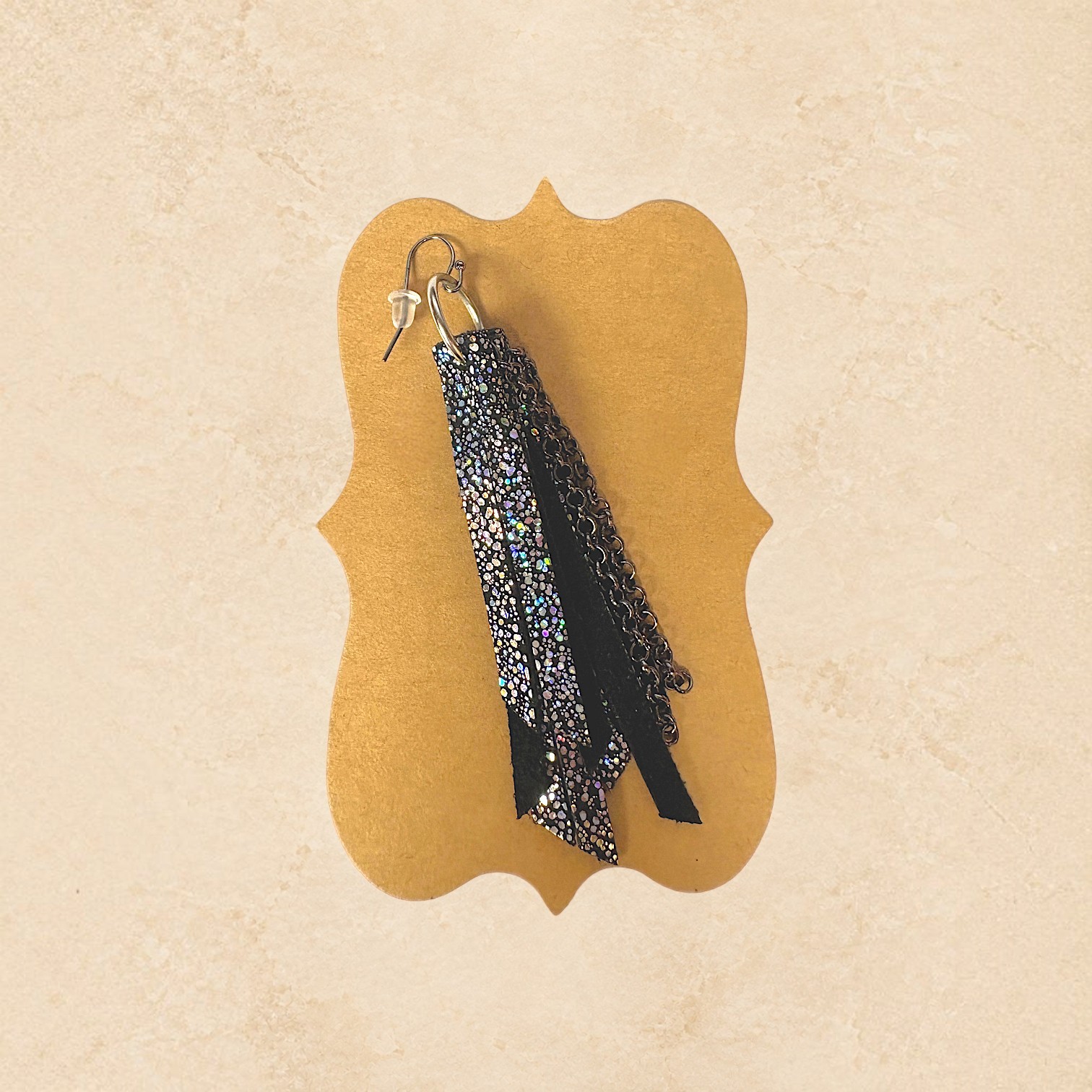 Black fringe earrings with shimmering metallic accents, chain details, and silver-tone hoops.