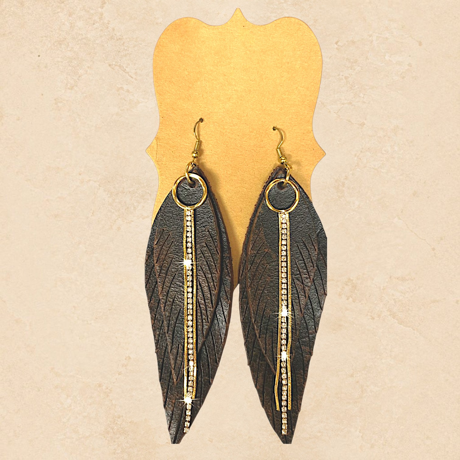 Dark brown feather earrings with gold-tone accents and sparkling rhinestone detailing