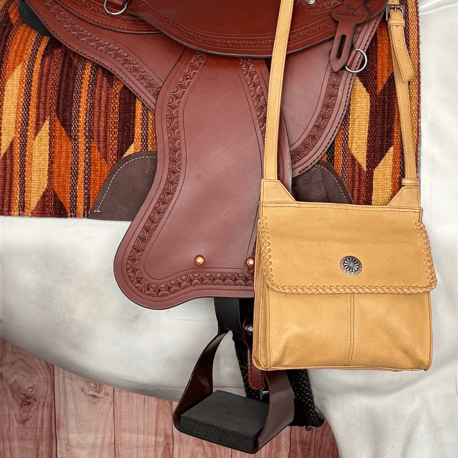 Golden tan Western crossbody purse with hand-laced edges and turquoise accent concho