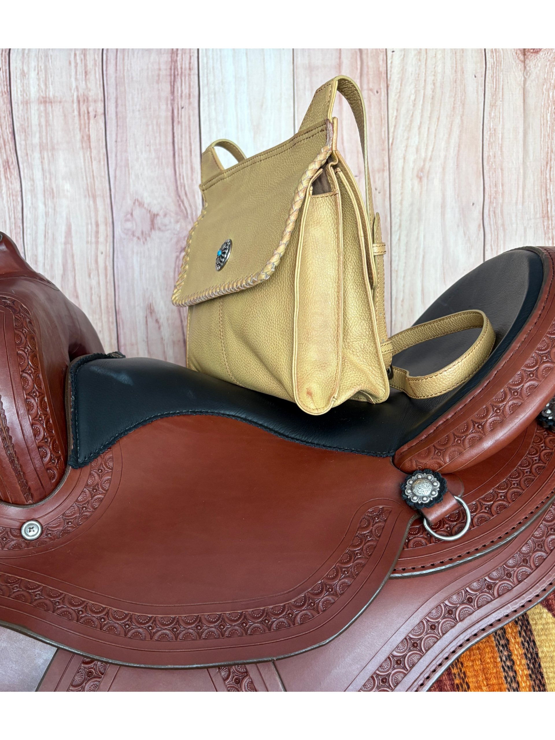 Golden tan Western crossbody purse with hand-laced edges and turquoise accent concho