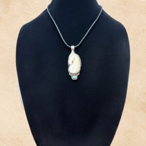 Ivory Horse necklace featuring a beautifully carved bone horse head pendant accented with a genuine turquoise stone and ornate Tibetan silver metalwork. The pendant hangs from a braided black leather cord with a convenient silver-toned magnetic closure.